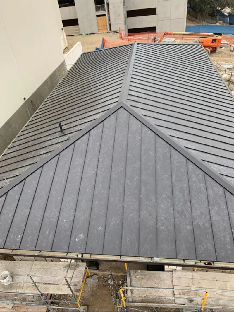 Commercial metal roof construction with crane equipment in Greenwood