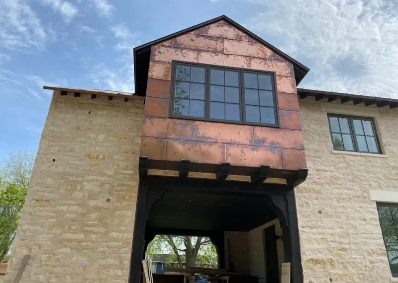 Copper metal panel facade on a stone building for Roof Repair in Greenwood